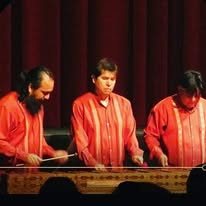 Músicos con camisa roja interpretando marimba